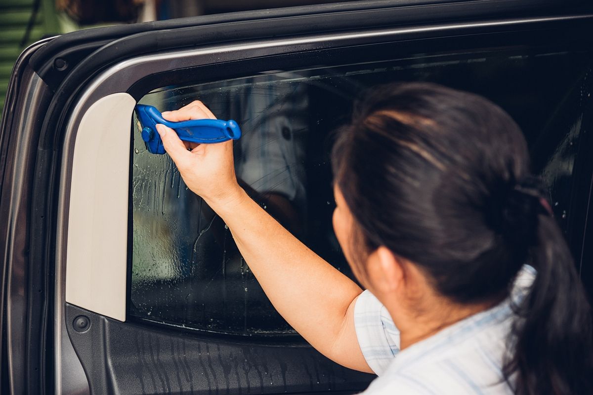 Auto glass company employee is tinting car side window